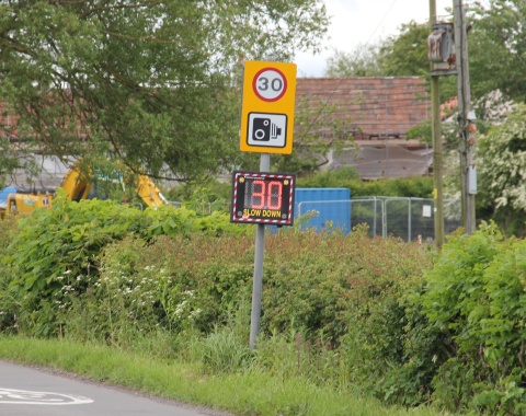 Speed indicator device illuminated - full sign post context