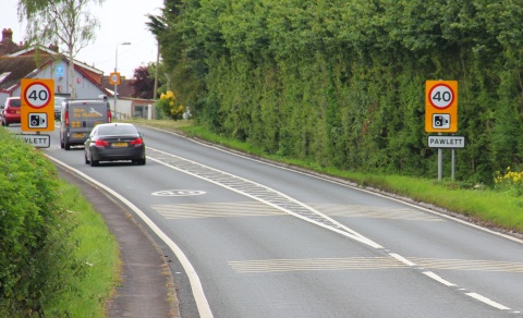 Signs for a new speed limit on high visibility backing board with speed camera warning